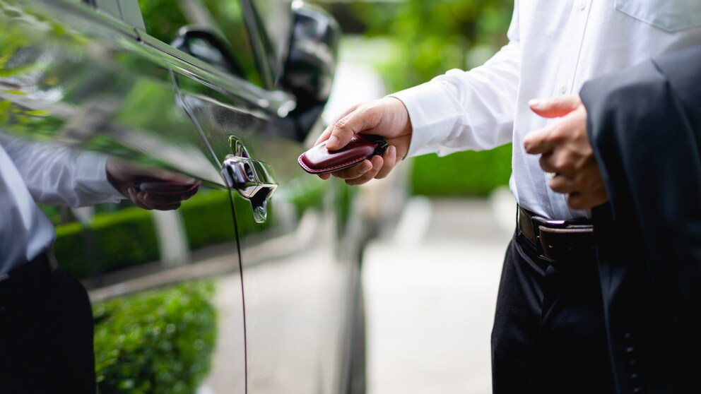 Symbolbild: Mann in Anzug entsperrt Auto per Keyless Go.
