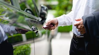 Symbolbild: Mann in Anzug entsperrt Auto per Keyless Go.