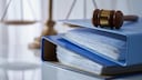 Blaue Ordner mit einem Richterhammer auf dem Tisch