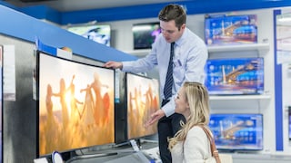 Fernseher kaufen im Laden: Frau mit TV-Verkäufer und Geräten