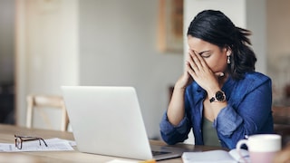 Frau im Home Office schlägt die Hände vor dem Gesicht zusammen, wegen einer Fehlermeldung auf dem Laptop.
