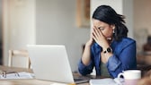 Frau im Home Office schlägt die Hände vor dem Gesicht zusammen, wegen einer Fehlermeldung auf dem Laptop.