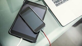 Symbolbild: Ladendes Tablet, auf dem ein ladendes Smartphone liegt.