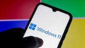 Windows 11 auf dem Smartphone mit Microsoft-Logo im Hintergrund