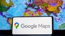 Google Maps Logo mit Weltkarte im Hintergrund