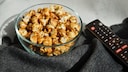 Streaming Begriffe Symbolbild: Fernbedienung neben Popcornschale
