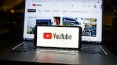 Youtube Logo auf Smartphone und Laptop im Hintergrund