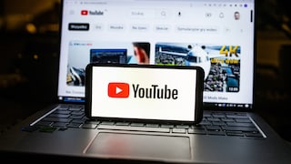 Youtube Logo auf Smartphone und Laptop im Hintergrund
