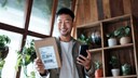 Mann mit Paket und Smartphone in der Hand