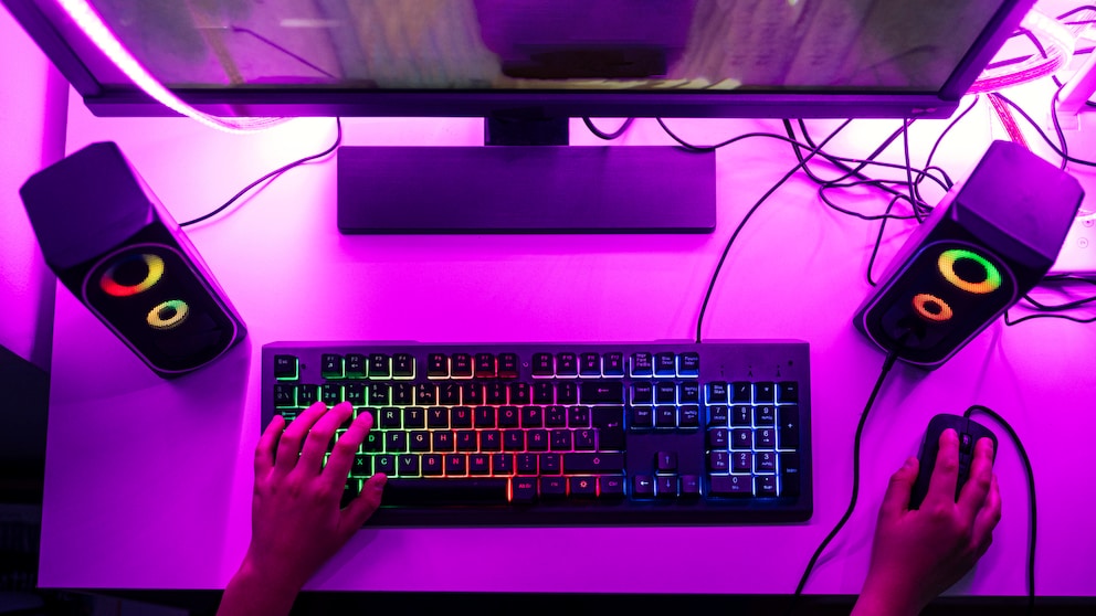 Gaming Black Friday: Gaming-Platz mit PC, Tastatur und Maus in lilafarbenem Licht