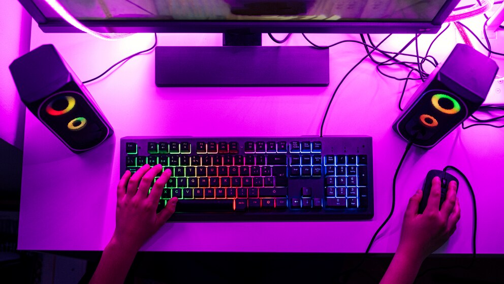 Gaming Black Friday: Gaming-Platz mit PC, Tastatur und Maus in lilafarbenem Licht