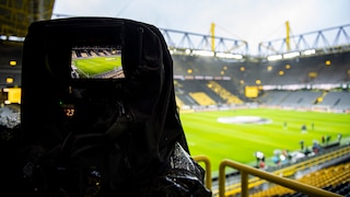 Symbolbild: Blick auf ein Fußballstadium durch eine Filmkamera.