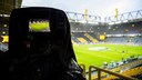 Symbolbild: Blick auf ein Fußballstadium durch eine Filmkamera.
