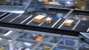 Symbolbild: drei Pakete auf einem Flie&szlig;band in einem Paketzentrum.