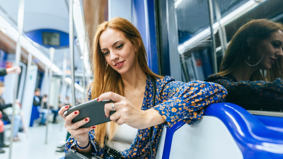 Mobile Games offline: Frau mit Handy in der U-Bahn