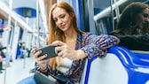 Mobile Games offline: Frau mit Handy in der U-Bahn