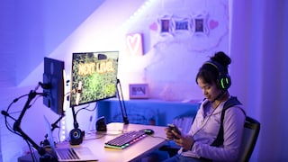 FPS vs Hz Symbolbild: Teenager mit Handy am Gaming-Monitor