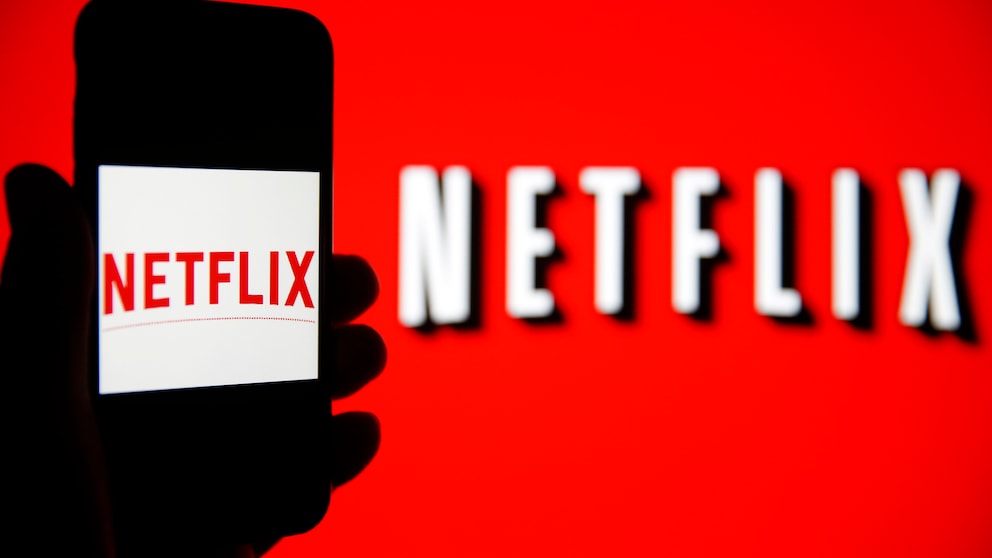 Netflix Empfehlungen Symbolbild: Netflix-Logo auf Smartphone und auf rotem Hintergrund