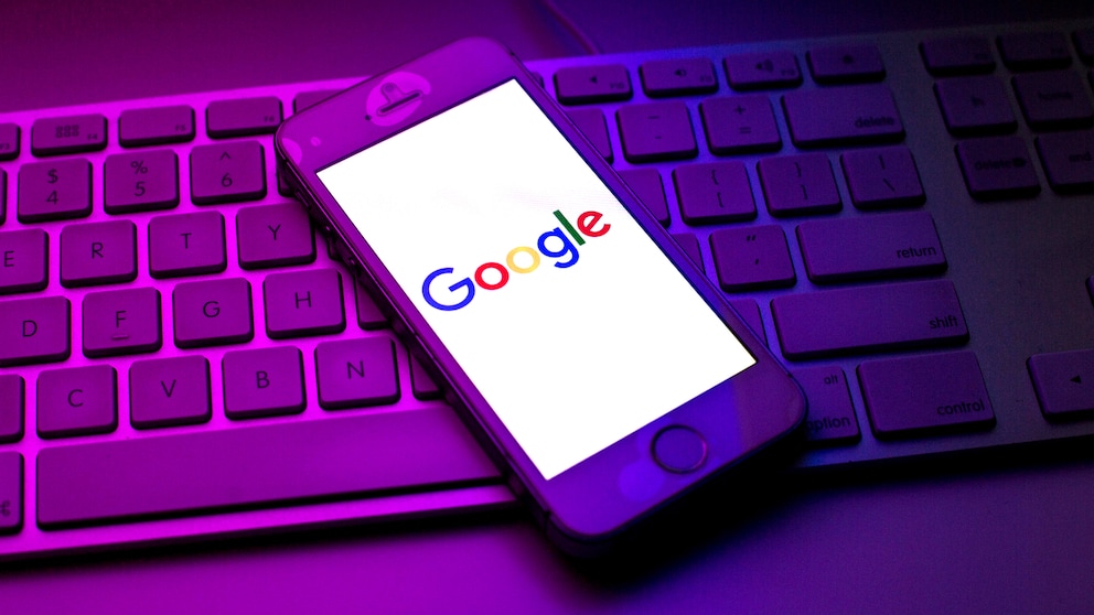 google konto trojaner Symbolbild: Smartphone mit Google-Logo liegt auf Tastatur