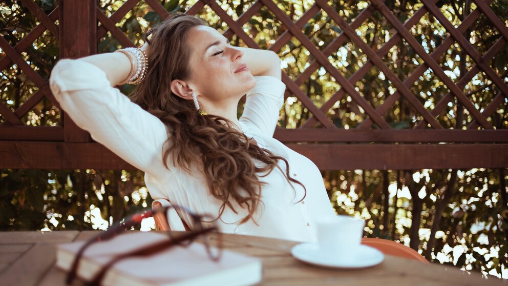Digital Detox Symbolbild: Eine Frau entspannt mit einer Tasse Kaffee