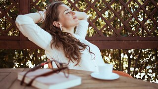 Digital Detox Symbolbild: Eine Frau entspannt mit einer Tasse Kaffee