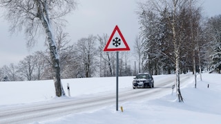Straße mit Auto, Schnee und Glatteis