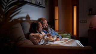 romantische Filme Netflix Symbolbild: Mann und Frau auf dem Sofa beim Fernsehgucken
