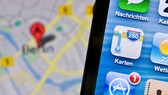 Altes Apple-Maps-Icon auf einem Handy, dahinter ein Kartenausschnitt für Berlin.