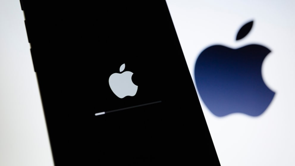 IPhone mit einem Ladebildschirm, im Hintergrund das Apple-Logo.