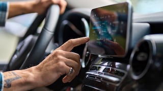 Mann im Auto bedient ein Touchscreen.