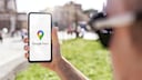 Person hält Smartphone mit Google Maps in der Hand.