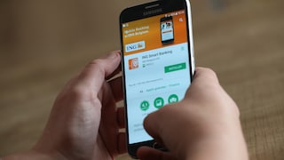 Symbolbild: Zwei Hände halten ein Smartphone, dass die ING-App im App Store zeigt
