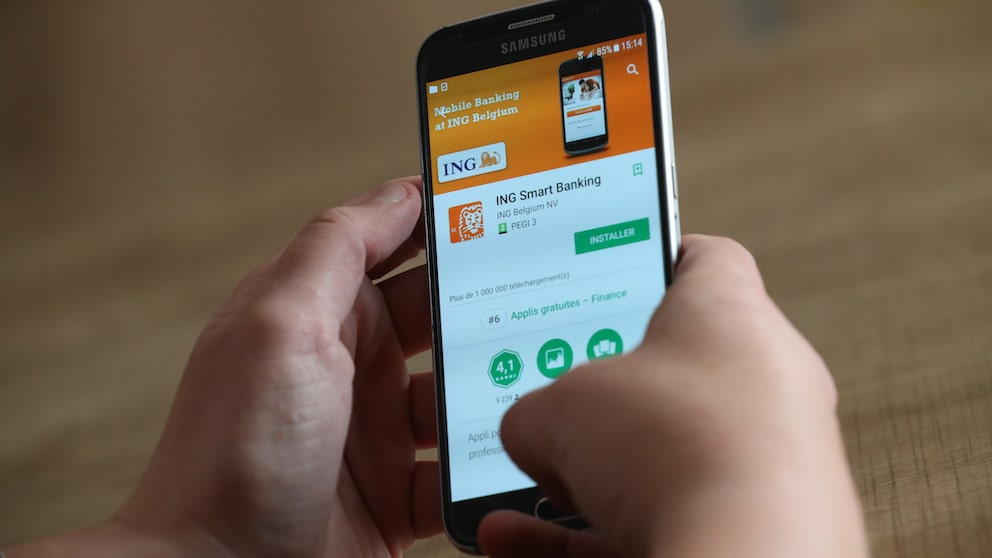 Symbolbild: Zwei Hände halten ein Smartphone, dass die ING-App im App Store zeigt