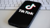 Handy mit TikTok-Logo auf einem Tisch.