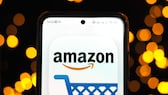 Amazon-Logo mit Einkaufswagensymbol auf einem Handy.