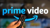 Person hält Fernbedienung in der Hand, dahinter das Logo für Amazon Prime Video.