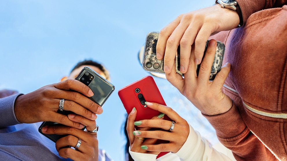 Apps nutzerfreundlich: Low-Angel-Sicht auf drei Personen mit Smartphones
