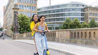 Beim E-Scooter-Fahren gibt es mehr Regeln, als gedacht: Zwei Fahrerinnen auf einem Roller – sind eigentlich verboten.