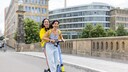 Beim E-Scooter-Fahren gibt es mehr Regeln, als gedacht: Zwei Fahrerinnen auf einem Roller – sind eigentlich verboten.
