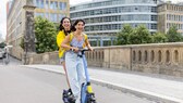 Beim E-Scooter-Fahren gibt es mehr Regeln, als gedacht: Zwei Fahrerinnen auf einem Roller – sind eigentlich verboten.