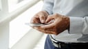 Europol SMS: Mann hält Smartphone in der Hand
