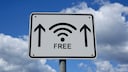 Symbolbild: Ein weißes Straßenschild weist die Richtung zu einem freien WLAN-Hotspot