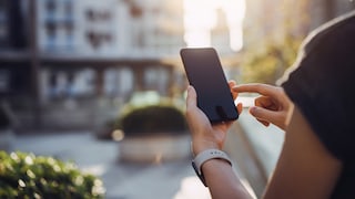 Person nutzt Smartphone im Freien.