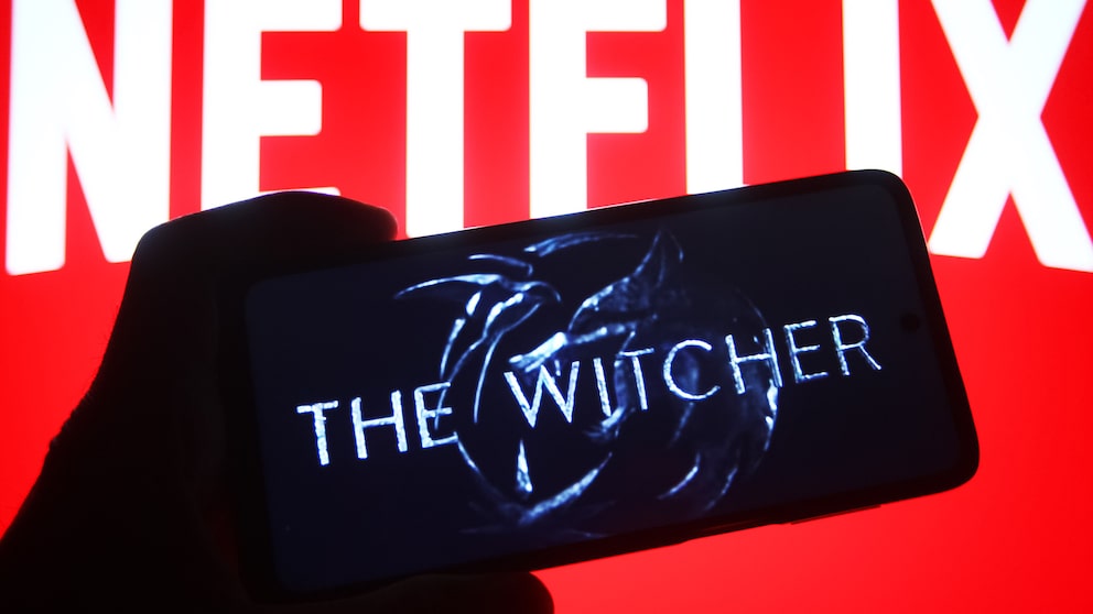 „The Witcher“-Logo auf einem Handy, dahinter ein Netflix-Schriftzug.