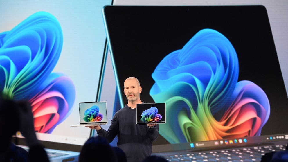 Microsoft-Manager Brett Ostrum zeigt ein Notebook und ein Tablet