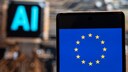 EU-Flagge auf einem Smartphone, im Hintergrund steht "AI" für "Künstliche Intelligenz".