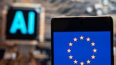 EU-Flagge auf einem Smartphone, im Hintergrund steht "AI" für "Künstliche Intelligenz".