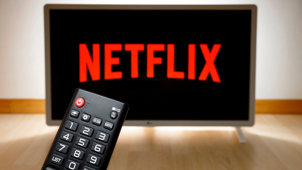 Netflix-Logo auf einem Fernseher, im Vordergrund eine Fernbedienung.