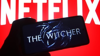 "The Witcher"-Logo auf einem Handy, im Hintergrund ein Schriftzug von Netflix.