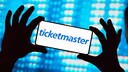 Ticketmaster-Logo auf einem Smartphone in Händen einer Person.